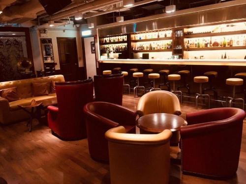 um bar com cadeiras de couro e um balcão de bar em Largos Hotel em Hong Kong