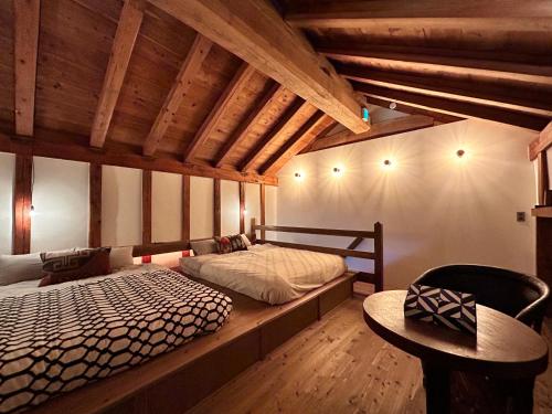 a bedroom with two beds in a room with wooden ceilings at The Bath and Bed Tateyama in Toyama
