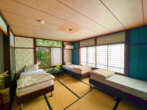 a large room with two beds and windows at Drive in Ichinomiya motel in Ichinomiya