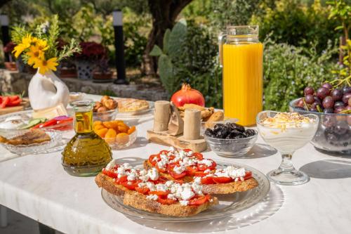 a table topped with sandwiches and fruit and orange juice at Spiros Family Apts in Laganas