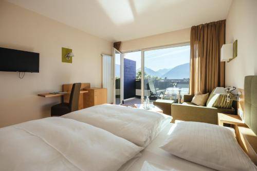 a hotel room with a bed and a large window at Hilburger Hotel in Schenna