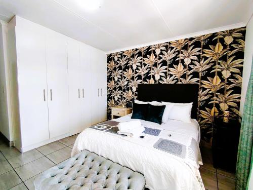 a bedroom with a bed and a black and white wallpaper at Mosseltjie - Self Catering in Britannia Bay