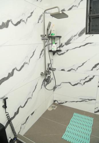a shower in a bathroom with black and white wallpaper at Mercella Homes - Munyonyo in Kampala