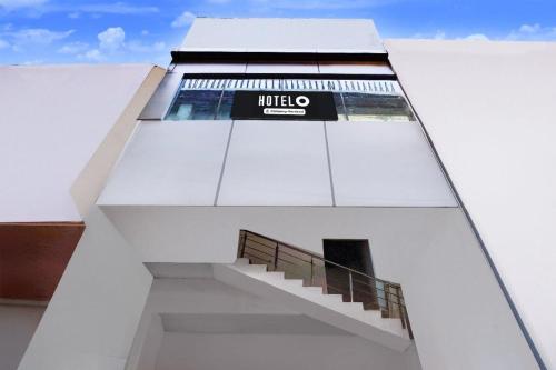 a white building with a staircase on the side of it at Hotel O Sector 110 Noida Formerly Luv Kush Tower Bhangel in Noida