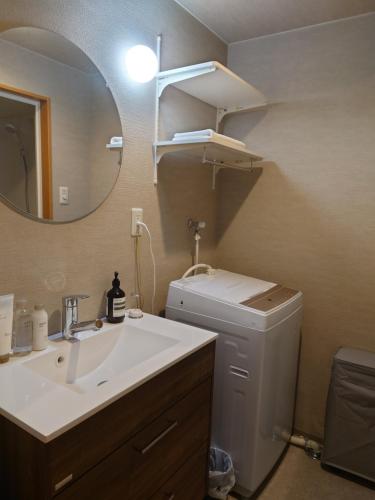 a bathroom with a sink and a toilet and a mirror at 大泉学園 練馬の家灯 池袋まで15分 としまえん 吉祥寺 飯能 観光に in Yagisawa