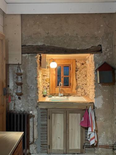 Una cocina con fregadero y una pared de piedra. en souslens, Castaignos-Souslens 40, en Castaignos-Souslens