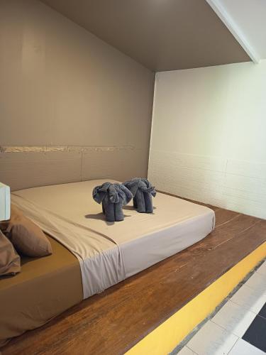 two stuffed elephants sitting on a bed in a room at Row House Long Beach in Ko Lanta