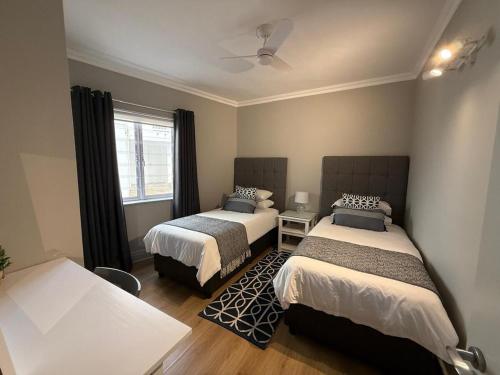 a bedroom with two beds and a window at The Tidal Court in Sea Vista