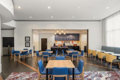a dining room with tables and blue chairs at Hampton Inn & Suites Baton Rouge Downtown in Baton Rouge