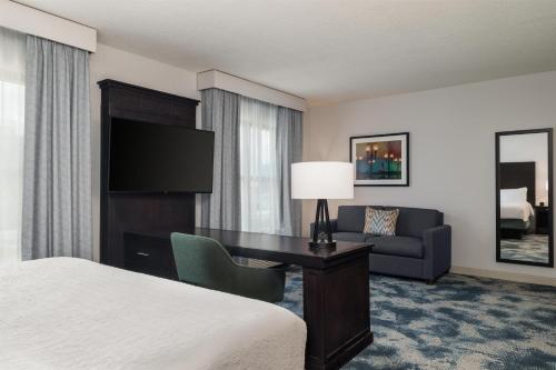 a hotel room with a bed and a desk and a couch at Hampton Inn & Suites Baton Rouge Downtown in Baton Rouge
