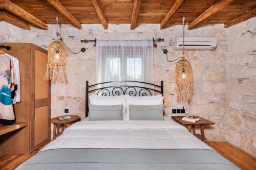 ein Schlafzimmer mit einem großen Bett in einer Steinmauer in der Unterkunft Petrino Eco Village in Afytos