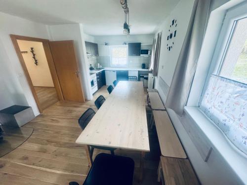 a room with a table and chairs and a kitchen at Chalupa Zdíkov na Šumavě in Zdíkov