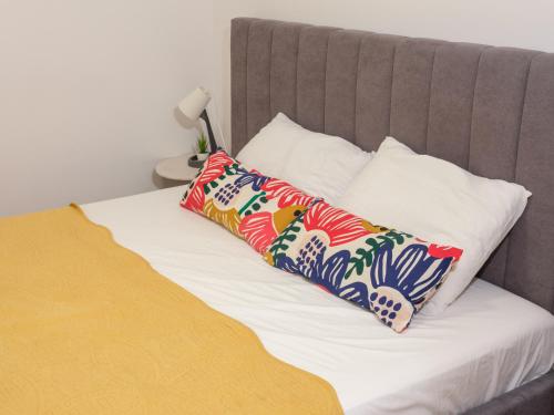 un letto con due cuscini colorati sopra di Sophie Studio - Top center, Cozy & Work-Friendly near AUBG, Free streaming platforms a Blagoevgrad
