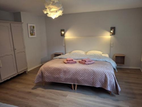 Scharrachbergheim IrmstettLe Repaire des Hirondelles - Le Colombage的卧室里有一张床，床上放着两条毛巾。