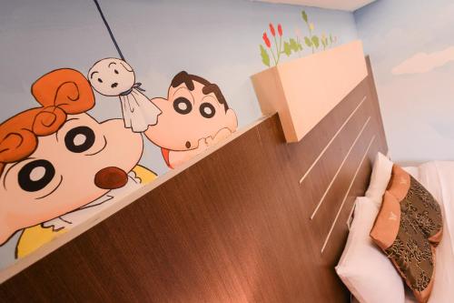 a childrens bedroom with a cartoon mural on the wall at Waugh Den Business Hotel in Taichung