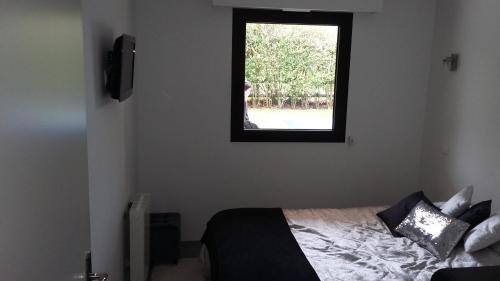 um quarto com uma cama e uma janela em Les Manoirs em Deauville