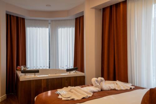 ein Schlafzimmer mit Badewanne und Bett mit Handtüchern in der Unterkunft Navoris Hotel in Istanbul