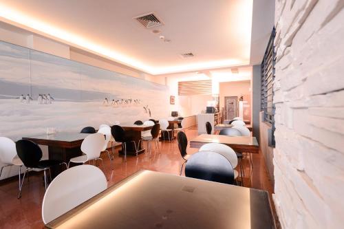 a dining room with tables and chairs and a wall at Waugh Den Business Hotel in Taichung