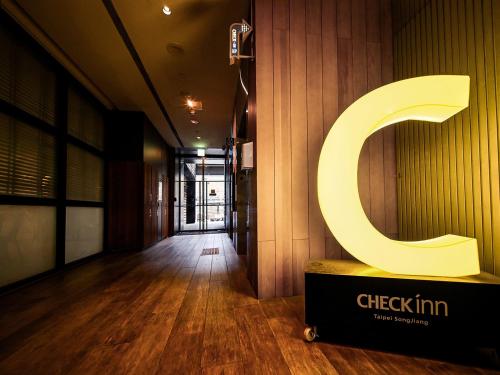 una hall con un grande cartello con la lettera C sul muro di CHECK inn Taipei Songjiang a Taipei