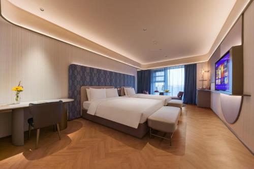 a hotel room with a large bed and a desk at Manxin Hotel, Jingshi Road, Zhangqiu District, Jinan 