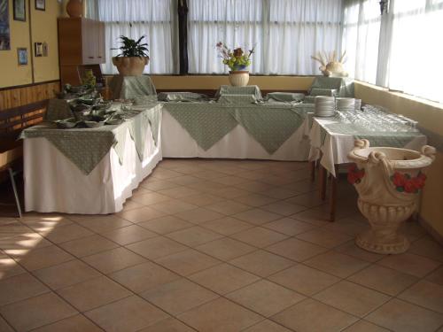 a dining room with two tables with dishes on them at B&B Ristorante Grotta Del Romito in Papasidero