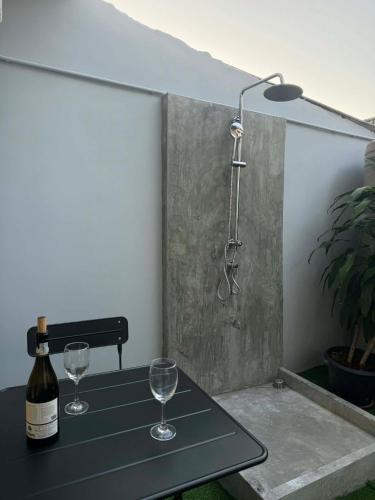 a table with two wine glasses and a shower at Scandi Haus near ChinaTown in Bangkok