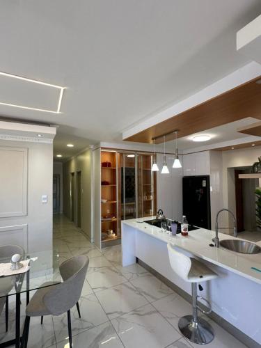 a large kitchen with a counter and chairs in it at Private Room behind Out of Africa in Otjiwarongo