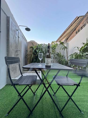 a table with a bottle of wine and two chairs at Scandi Haus near ChinaTown in Bangkok