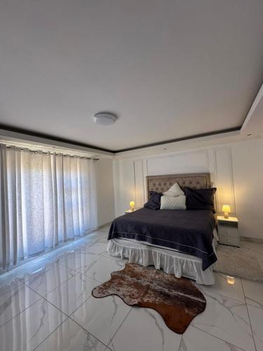 a bedroom with a bed and a rug on the floor at Private Room behind Out of Africa in Otjiwarongo