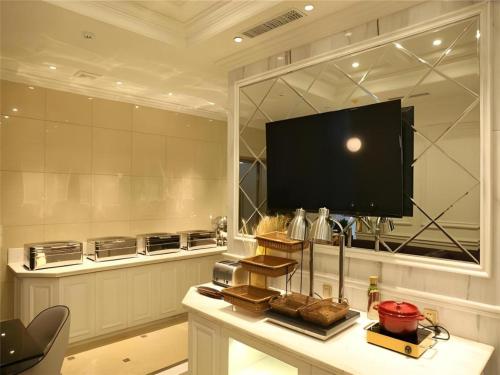 a kitchen with a tv and a table with bread at Jinjiang Inn Select Harbin Zhongyang Street Pedestrian Street Airport Bus Station in Harbin
