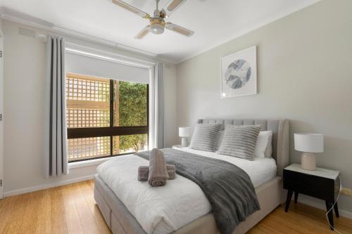 Un pat sau paturi într-o cameră la Beleura's Beachside Beauty