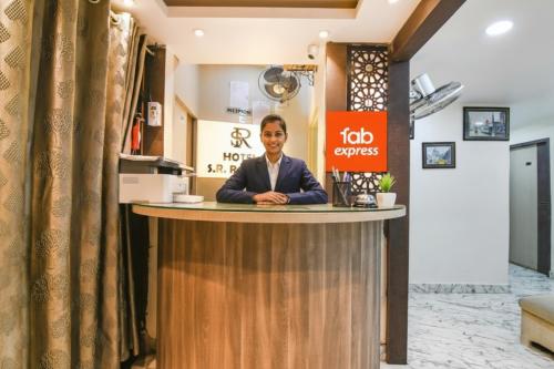 a man sitting at a counter in a hotel lobby at Via SR Royale - Nr Sealdah Station in Kolkata