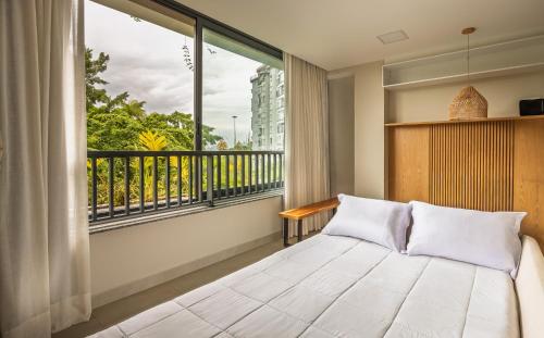 ein Schlafzimmer mit einem Bett und einem großen Fenster in der Unterkunft Luxo na Gloria in Rio de Janeiro