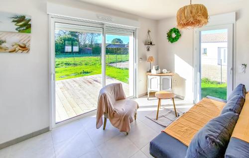 Maison Au Coeur De La Vendée في La Jonchère: غرفة معيشة مع أريكة وباب زجاجي منزلق
