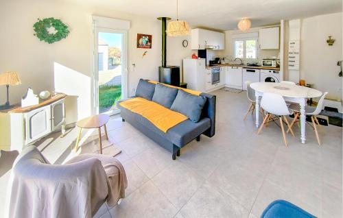 Maison Au Coeur De La Vendée في La Jonchère: غرفة معيشة مع أريكة زرقاء وطاولة