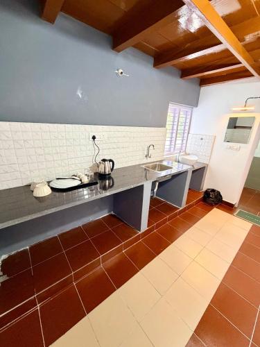 a kitchen with a counter with two sinks and a counter at Wildcrest Homestay in Madikeri