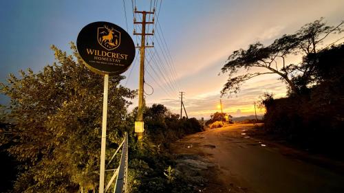 a sign on the side of a dirt road at Wildcrest Homestay in Madikeri