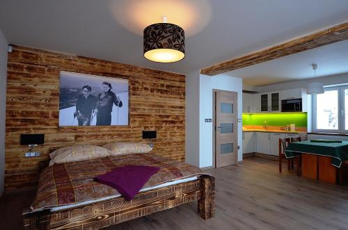 Schlafzimmer mit Ziegelwand und großem Bett in der Unterkunft Apartmány Benecko 155 in Benecko