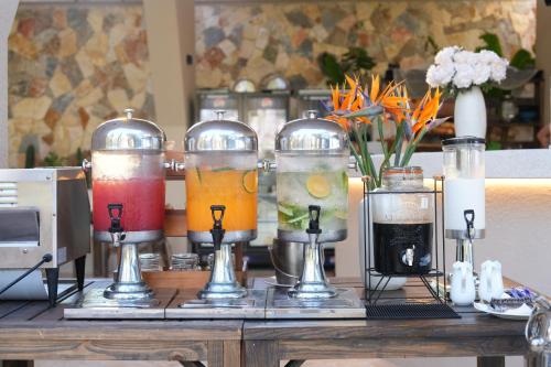 um grupo de quatro bebidas diferentes em recipientes de vidro sobre uma mesa em De' Tuva Resort Mui Ne em Mui Ne