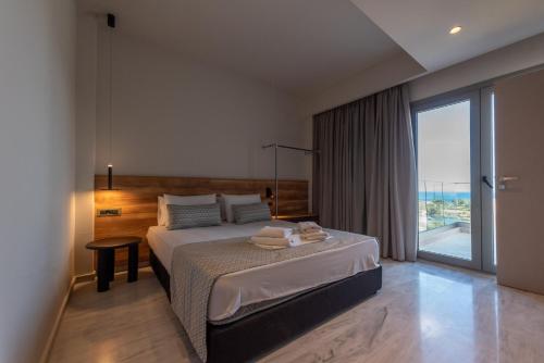 a bedroom with a bed and a large window at Villa Dorothea in Georgioupoli