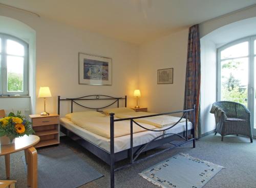 a bedroom with a bed and two windows at Villa Seegarten in Boltenhagen