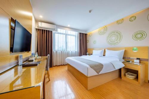 GreenTree Inn Huayin Huashan Town Huashan Scenicspot Express Hotel في Huayin: غرفة فندقية مع سرير كبير وتلفزيون بشاشة مسطحة