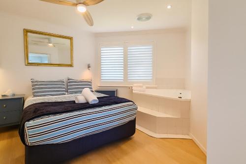 a bedroom with a bed and a bath tub at Sunset Spa Escape - Ocean Views in Perth