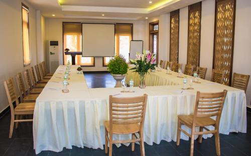 a long table in a room with chairs and a screen at Sonata Resort & Spa in Phan Thiet