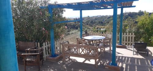 a patio with a table and chairs and a blue pergola at Finca Sencilla in Mijas