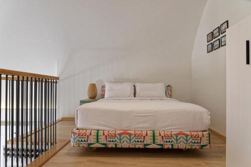 a white bedroom with a bed and a staircase at VESTA - El Gouna Residence in Hurghada