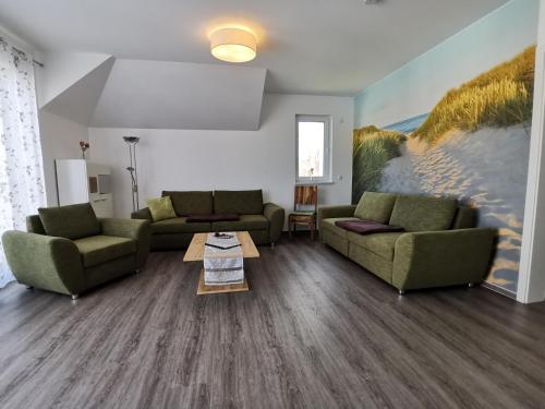 a living room with two couches and a table at Ferienwohnung in Zingst Müggenburg, hochwertig und ruhig urlauben in Müggenburg