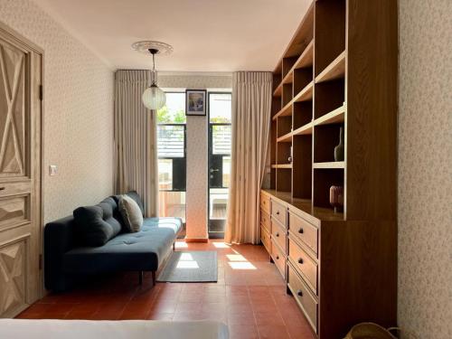 ein Wohnzimmer mit einer Couch und einem Bücherregal in der Unterkunft The TownHouse - Neve Zedek in Tel Aviv