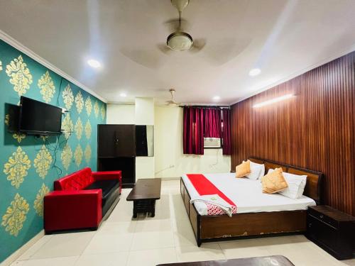 Un dormitorio con una cama y una silla roja. en Imperial Residency - Karol Bagh, en Nueva Delhi