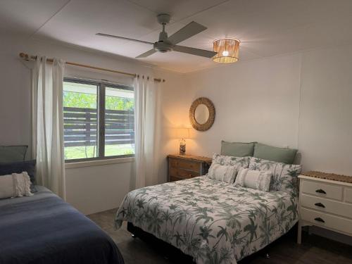 una camera da letto con un letto e un ventilatore a soffitto di Surf N Earth - Rainbow Beach a Rainbow Beach